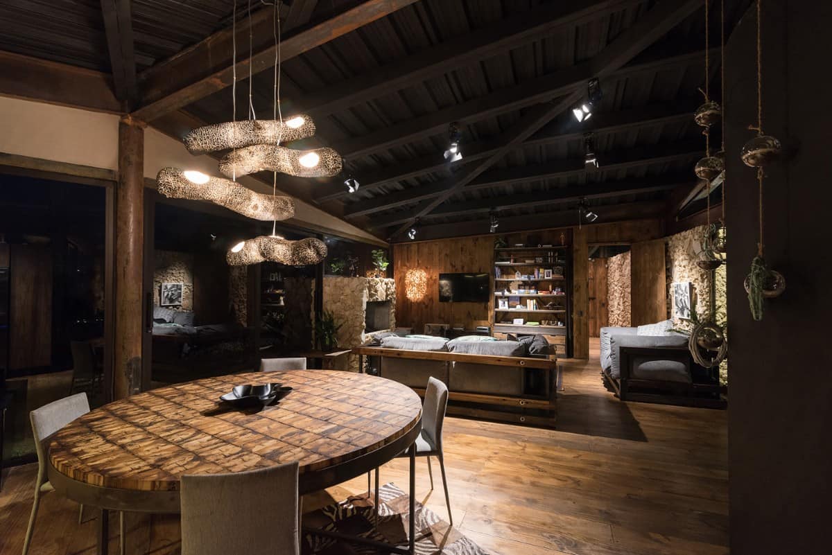 The living area is warm and cozy. It is surrounded by stone and wood-paneled walls echoed from the exterior.