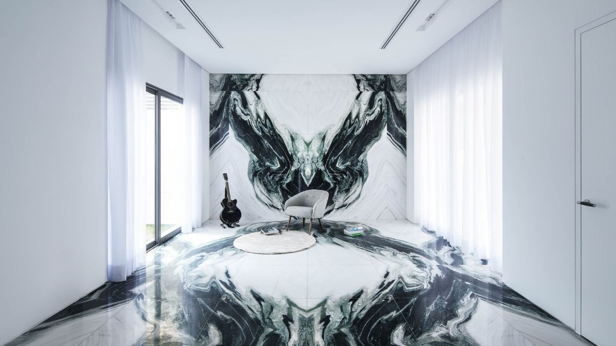 The spacious room features a large wall decor art of a character and a placed guitar.