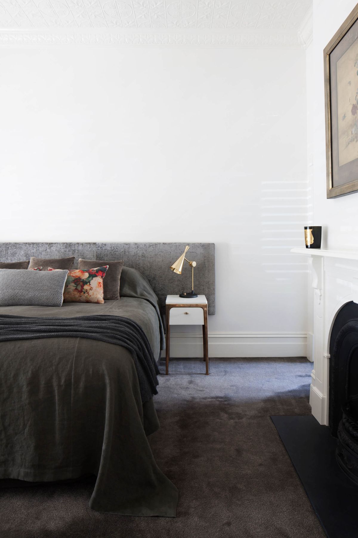 The bedroom features a queen-sized bed and a wall-to-wall carpet.