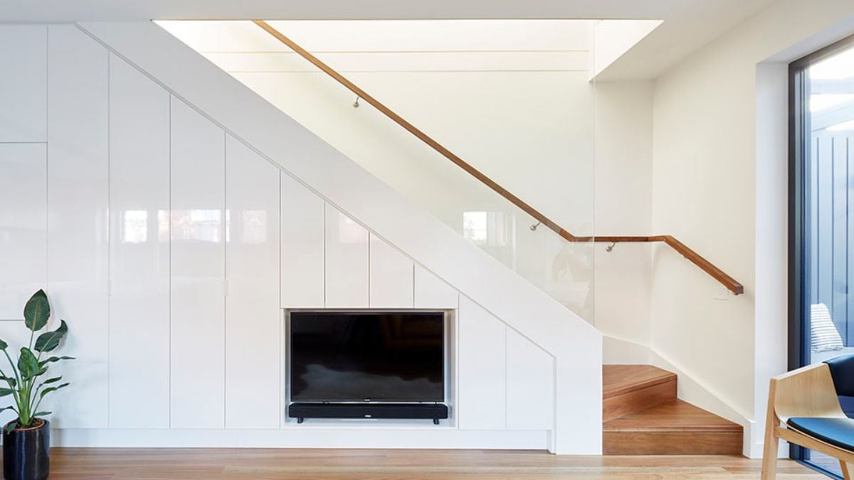This photograph features the staircase in the house, prominently displaying the attached fireplace.