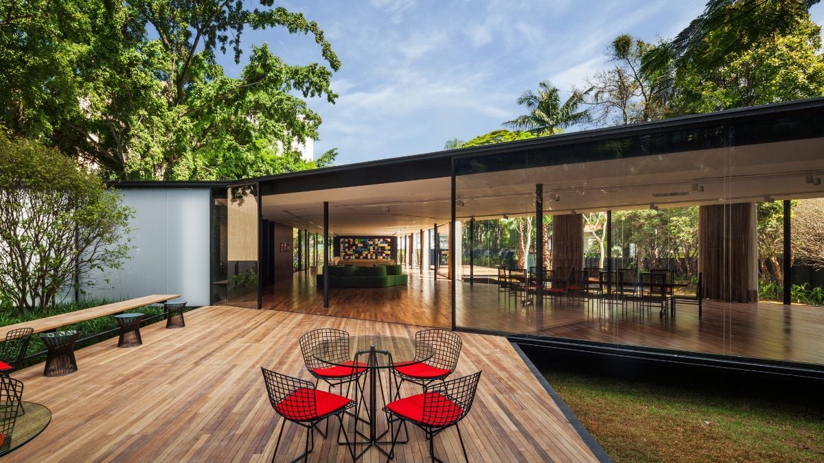 Outside, there is a seating area with a wooden floor that complements the surrounding natural materials.
