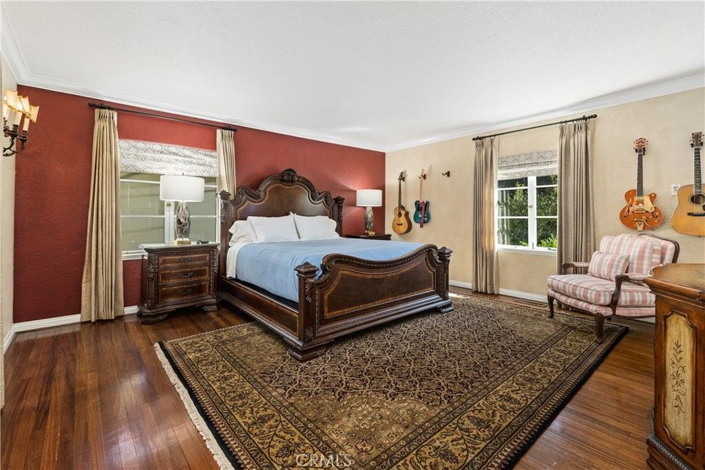 The bedroom features a bed with a wooden headboard and a carpet that gives the room a cozy feel.