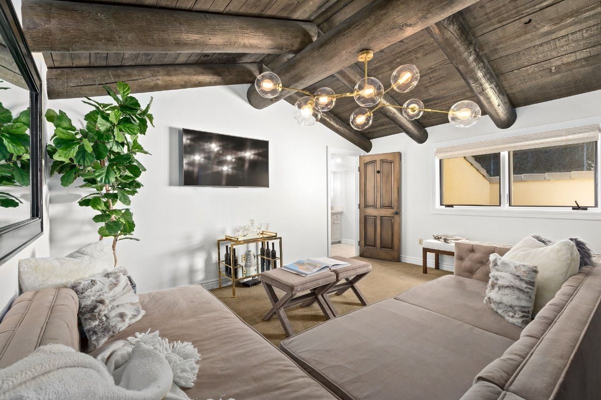 The cellar features a sectional sofa, and the logs that are used as beam gives the room a rustic feel.
