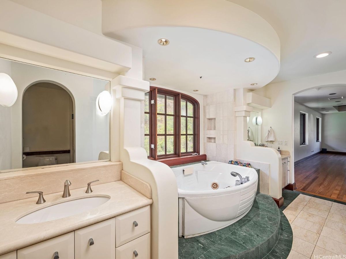 The master bathroom features a built-in bathtub and a vanity with a tile countertop.