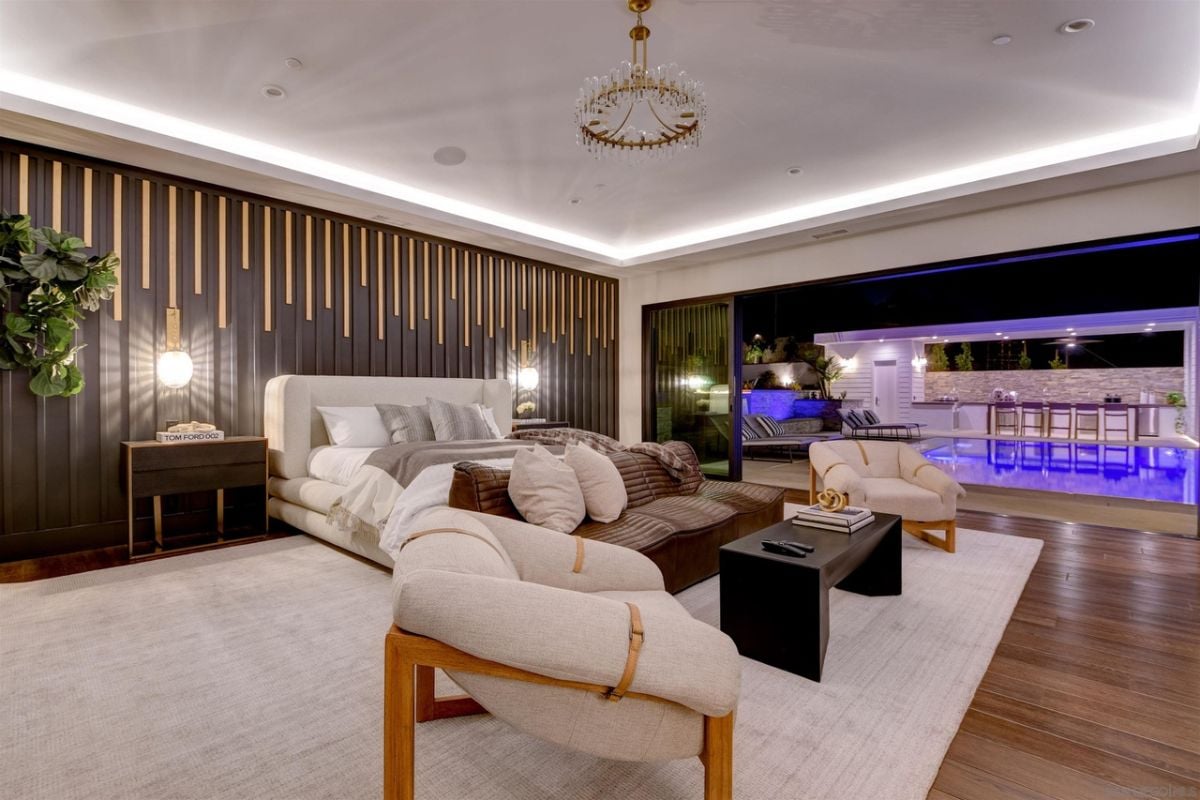The master suite features a leather sofa and a glass wall that showcase the pool.
