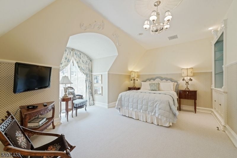 The bedroom is designed with beautiful ceiling lamps and nightstands.