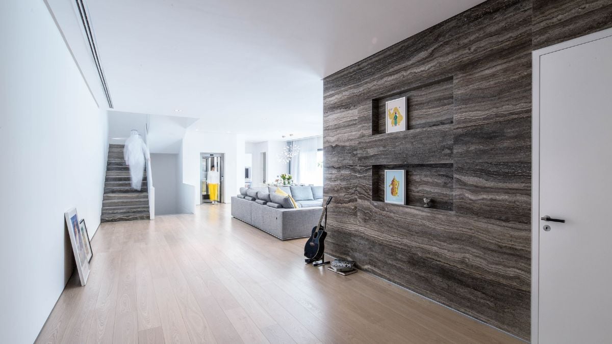 The spacious living room has an earthy stone wall that can accommodate wall arts or canvases.