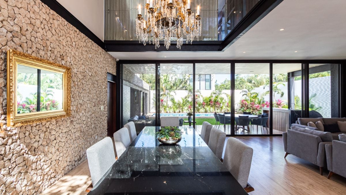 This photograph captures the refined aesthetic of the dining area, highlighting the tasteful interior design elements such as the lengthy dining table and ornate chandelier.
