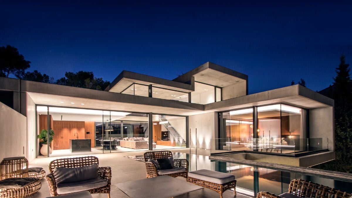 This is a photograph captured during nighttime of an outdoor living area located adjacent to a swimming pool.