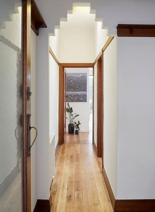 The provided photograph displays a hallway that leads to various areas of the house.