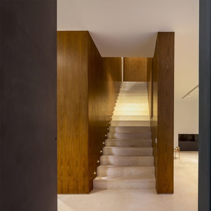The photograph features a focused shot of a straight staircase on the ground floor, showcasing its design, materials, and unique features.