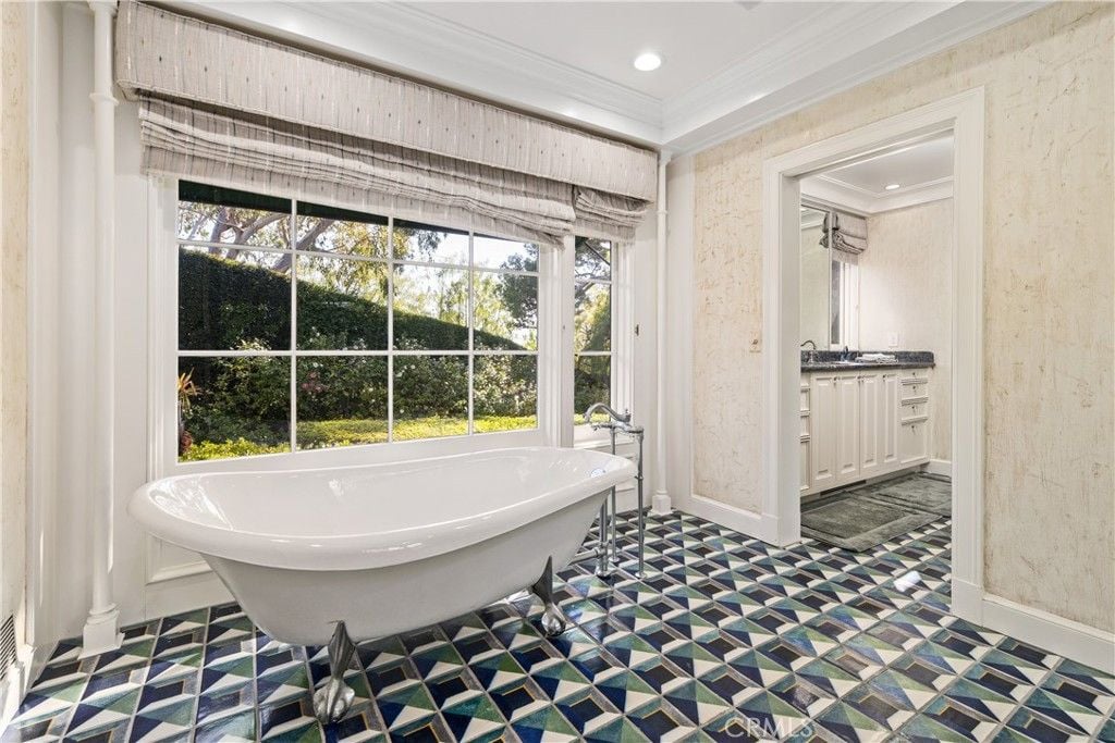 The bathroom features a free-standing bathtub and glass windows to showcase the surroundings.