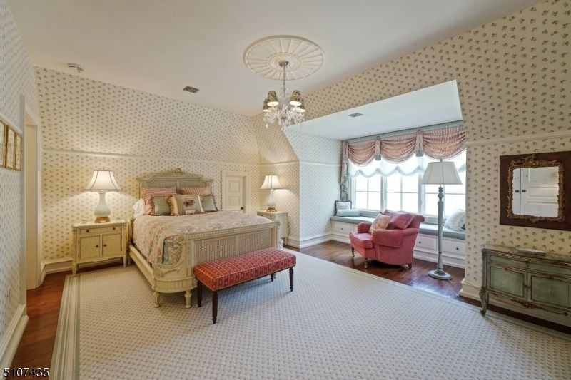 The bedroom for the ladies features a bedroom bench, and the wall decor gives the room a luxurious feel.