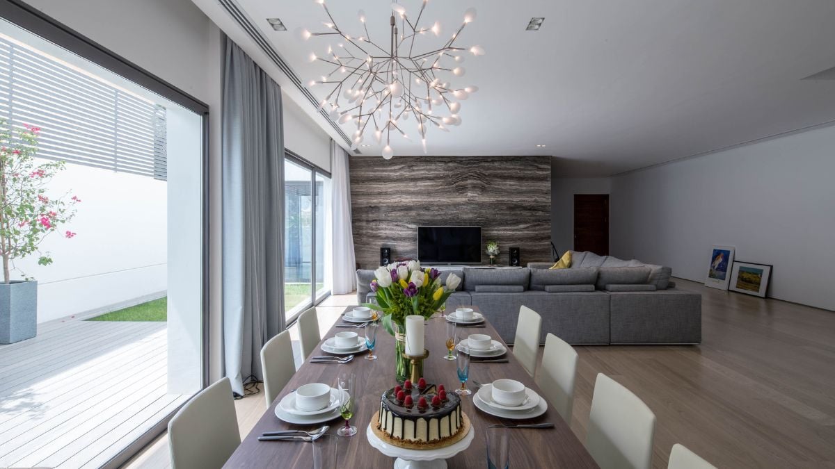 Interior shot of spacious dining and living room facing a large glass wall.
