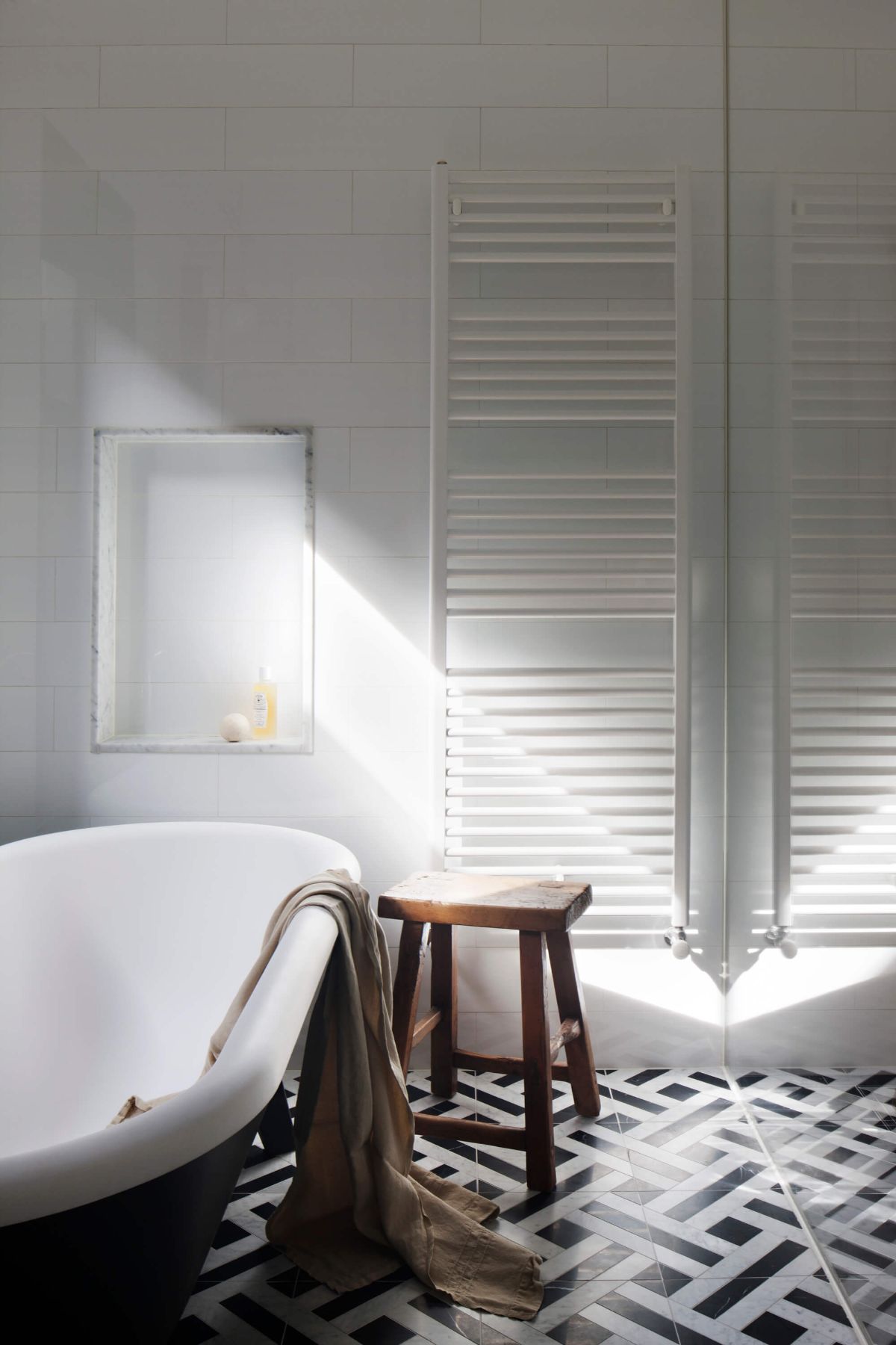 The bathroom features a free-standing bathtub and tile flooring.
