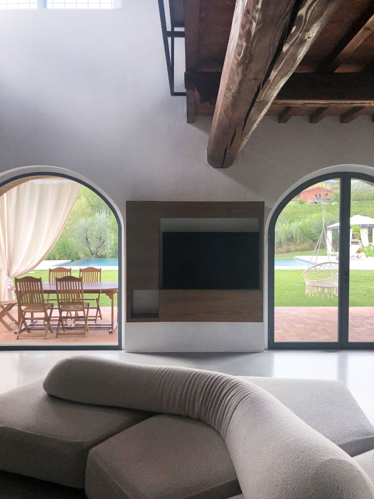 The house features archways leading to the backyard with a covered patio.