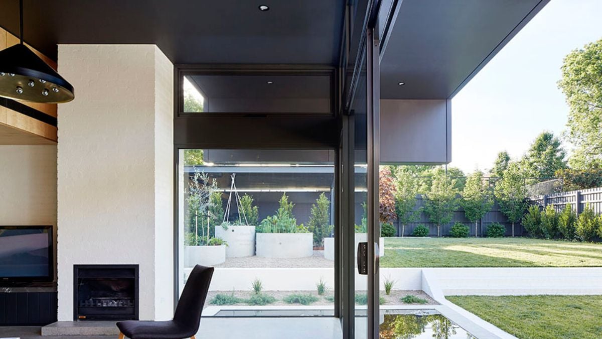 This interior photograph showcases a panoramic view from the living room, with expansive glass panels offering an unobstructed view of the outdoors.