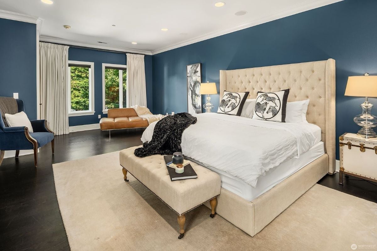 The bedroom features a queen-size bed and a bedroom bench, giving off a luxurious feel to the room.