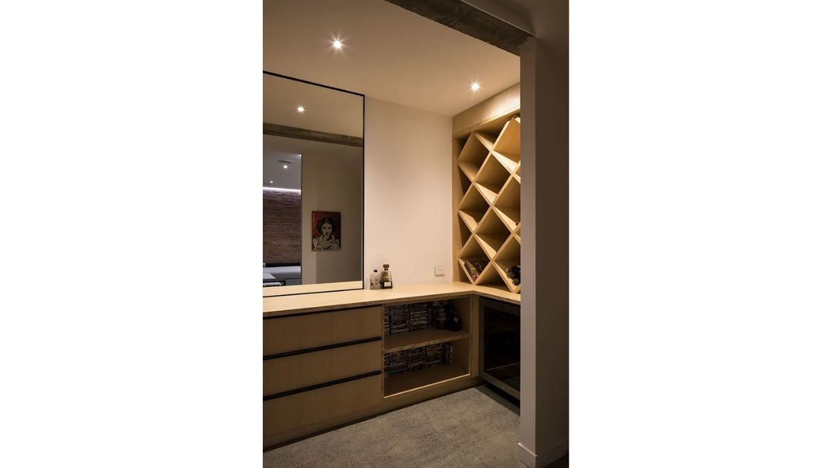 This space contains a mirror, hardwood furniture with a distinctive cabinetry design, and dim lighting.