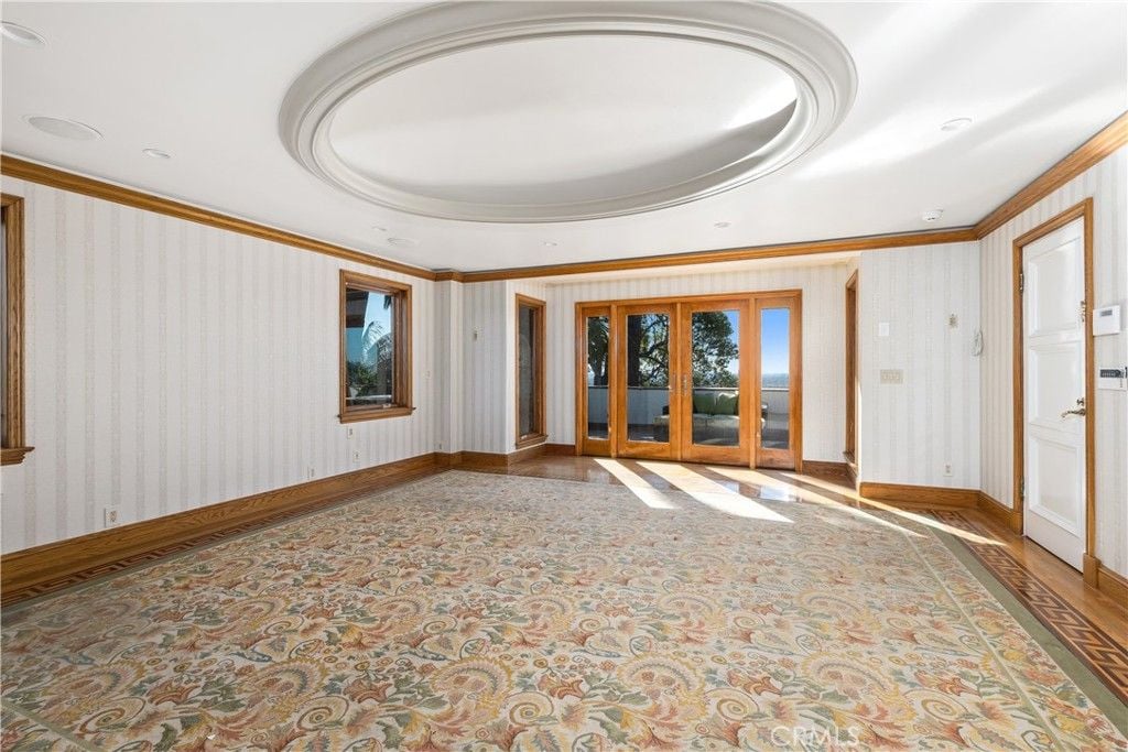 A multipurpose room with round ceiling art and artistic tile flooring.