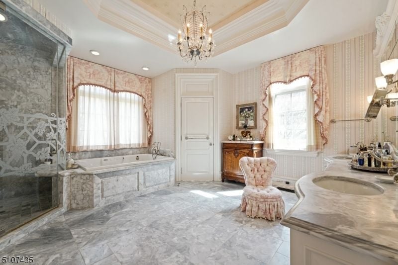 The master suite's bathroom features marble flooring and a bathtub.