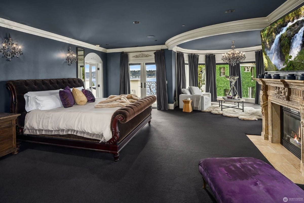 The en-suite features a king-size bed, a wall-to-wall carpet, and a fireplace, giving off a cozy feel to the room.