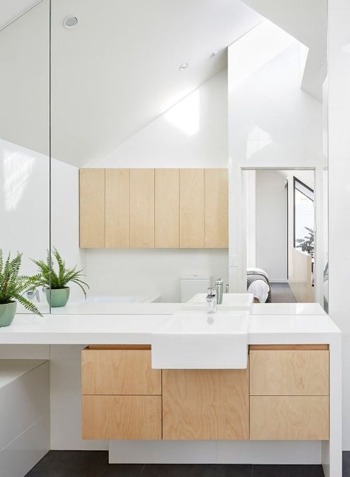 The provided image showcases the interior of the bathroom with a minimalist design, featuring a single basin sink and an expansive mirror wall.