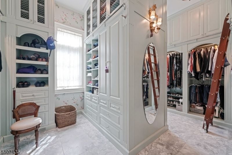 The master suite features a dresser designed with luxurious wall lamps.