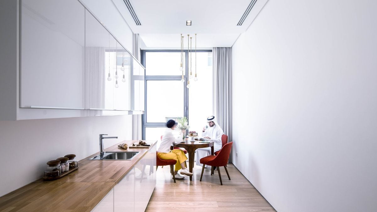 White-painted kitchen with brown countertop in a confined space.