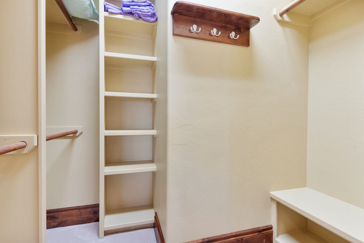 An empty dresser with wooden curtain rod.