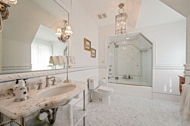 The bathroom features a shower room and silver-plated fixtures giving the room a luxurious feel.