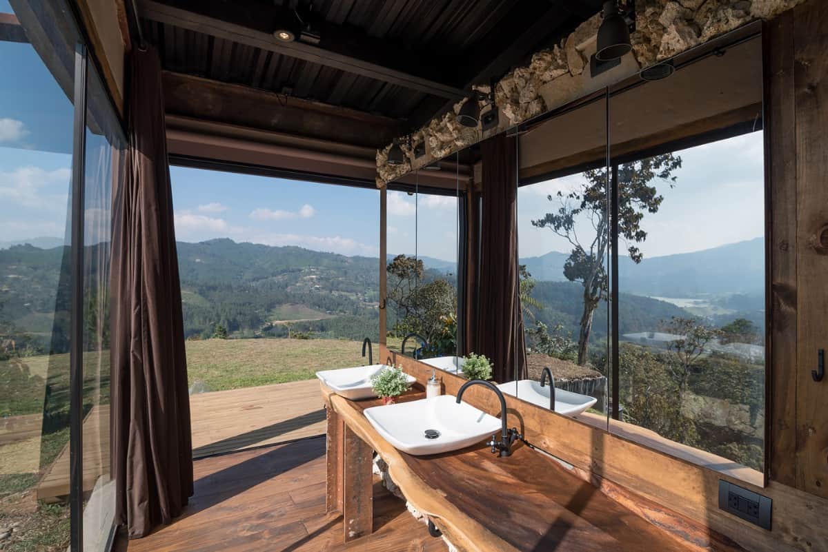The bathroom feels very open with its surrounding glass walls.
