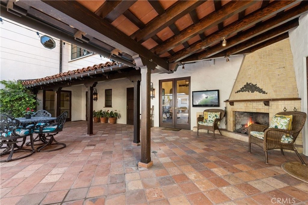 The balcony features tile flooring and an outdoor fireplace, giving off a classic feel to the place.