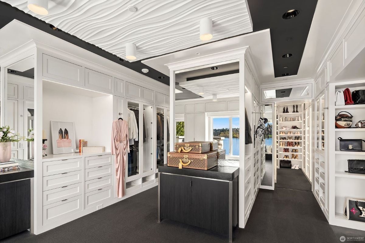 The en-suite dresser has a wall-to-wall carpet and a closet with different kinds of clothes.