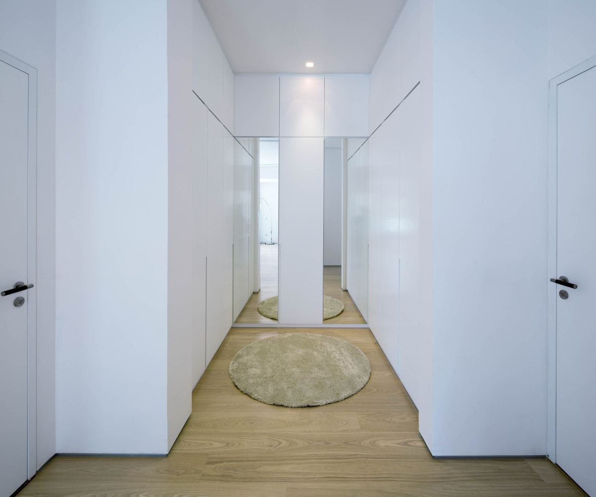 Vertical mirror on wall creates spacious illusion in T-shaped access section.