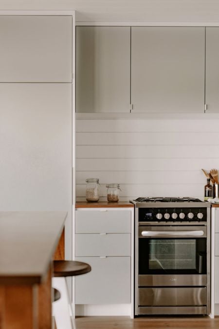 A photograph capturing a portion of the kitchen, emphasizing the compact cabinet and the freestanding cooking stove with oven.