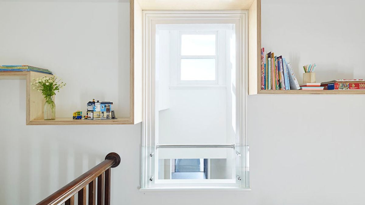 A wall featuring floating shelves holding books and other items.