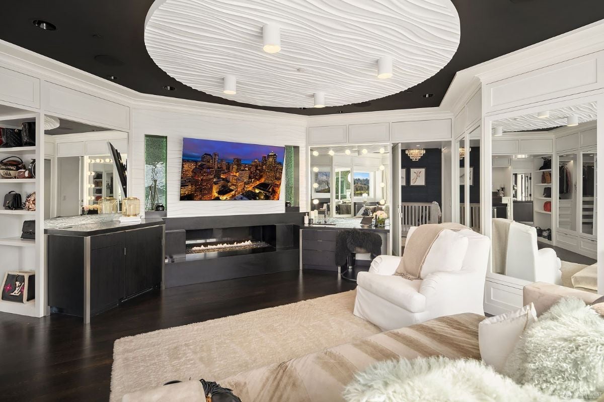 The en-suite lounge features a cozy sofa and an electric fireplace that warm the room.