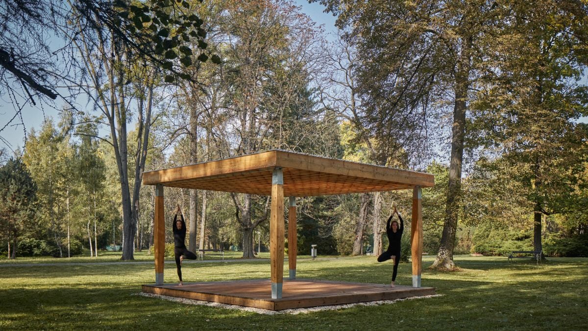 Captured from an alternative viewpoint, this photo showcases the larger Yogapoint structure and the natural environment that surrounds it, featuring a range of verdant trees and plants that provide a calming backdrop.