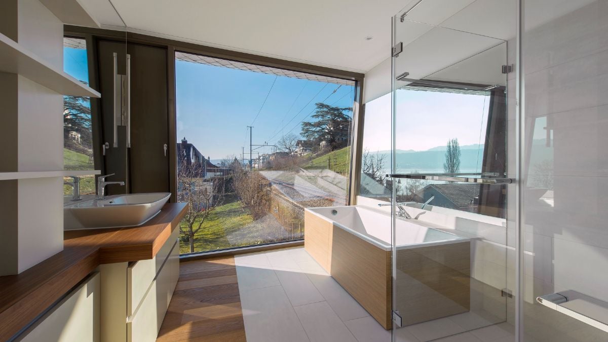 The huge glass windows in the bathroom provide a beautiful outlook.
