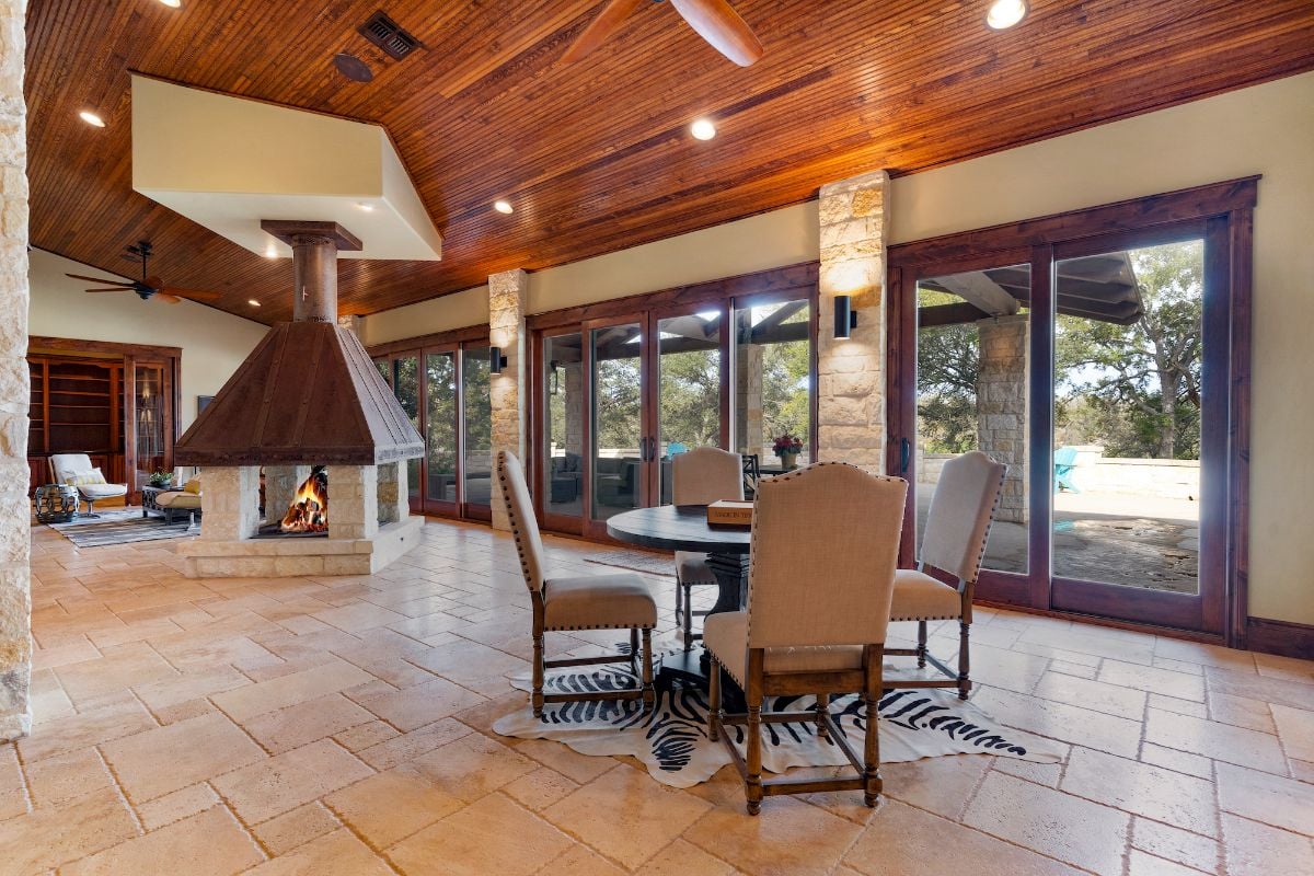 A dinette by the entrance and the wooden fireplace in the middle of the room.
