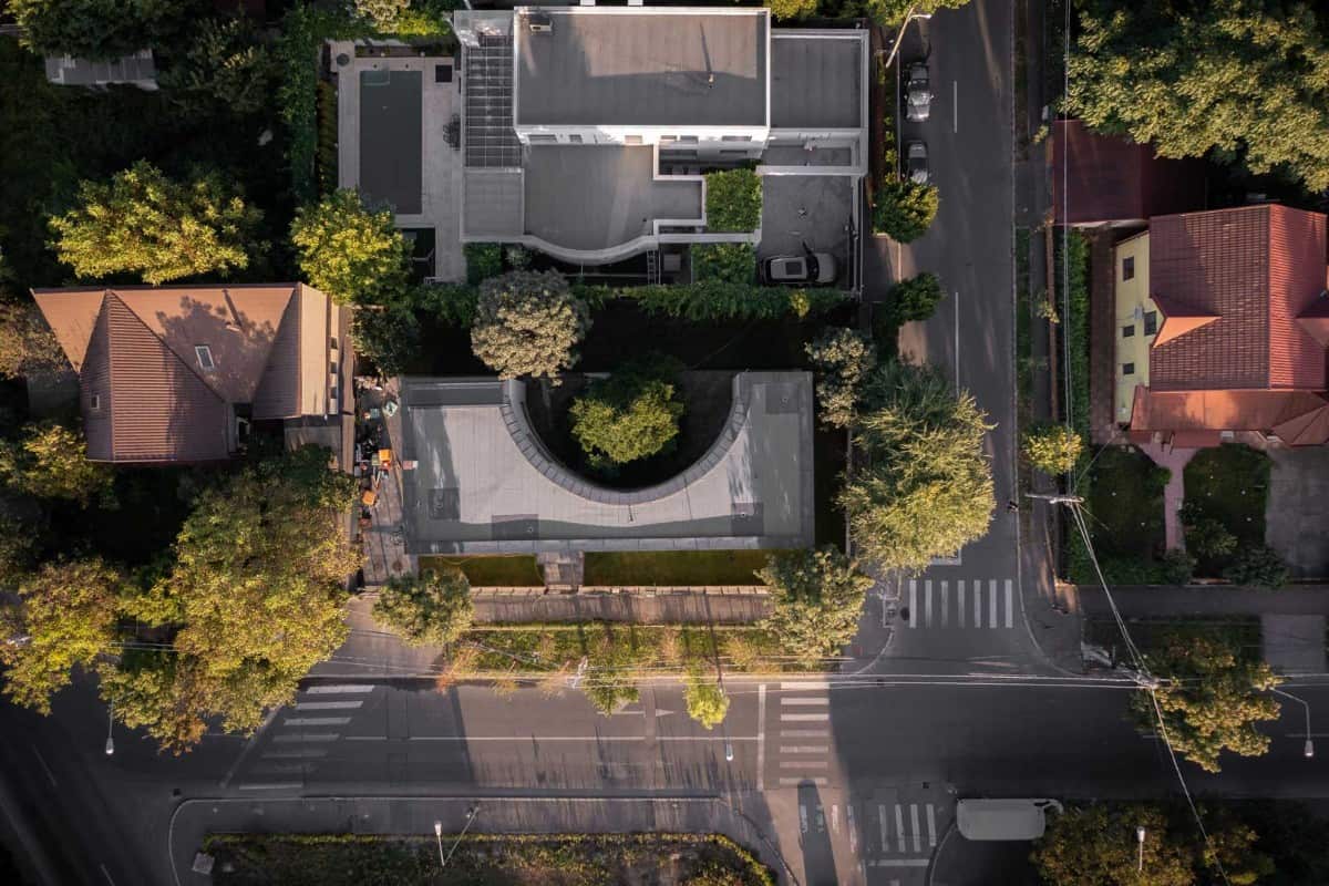 Bird's eye view of the house showcasing its perimeter surrounded by tall and lush trees.