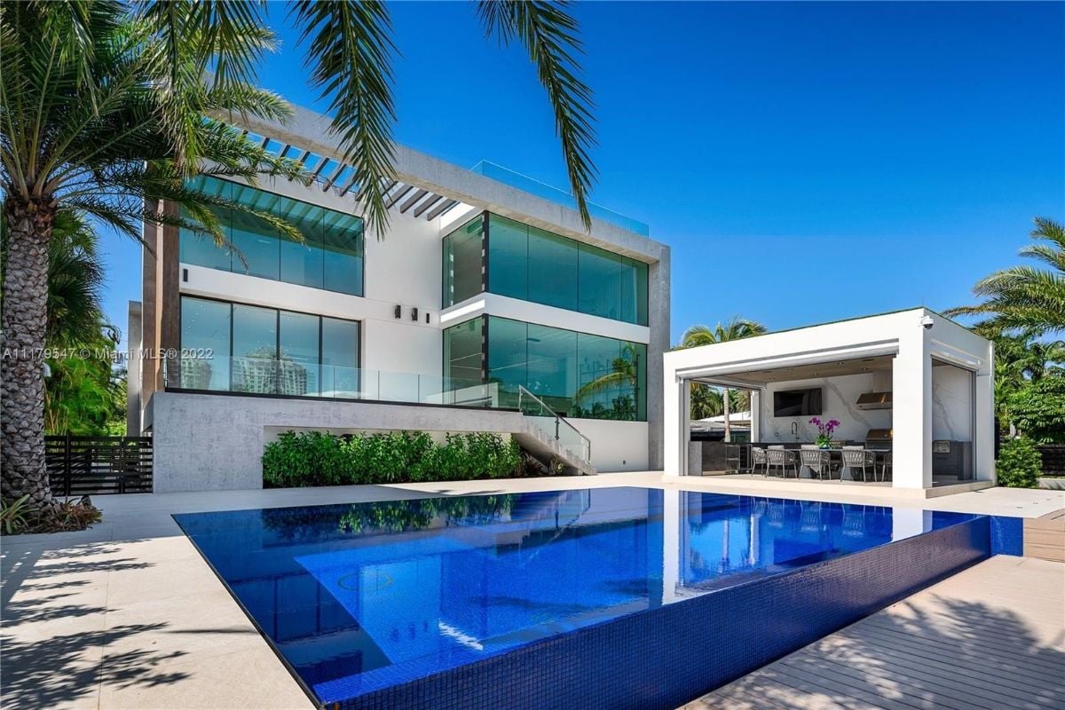 The outdoors features a swimming pool and an open dining area for recreation.
