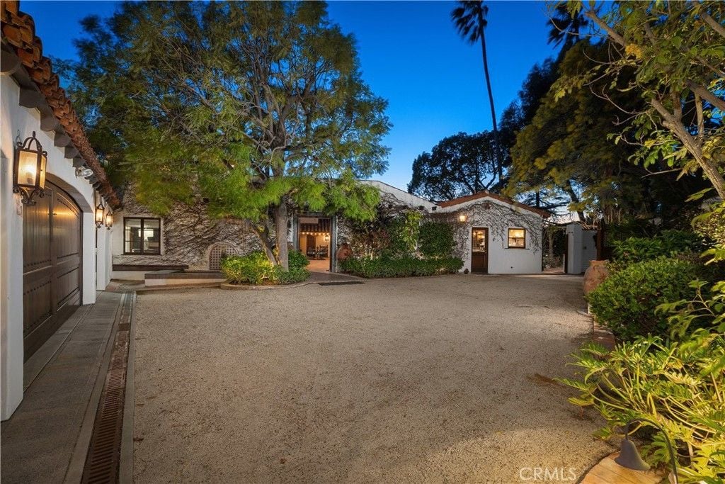 The entrance features a wooden gate with antique wall lighting, giving off a classic feel.