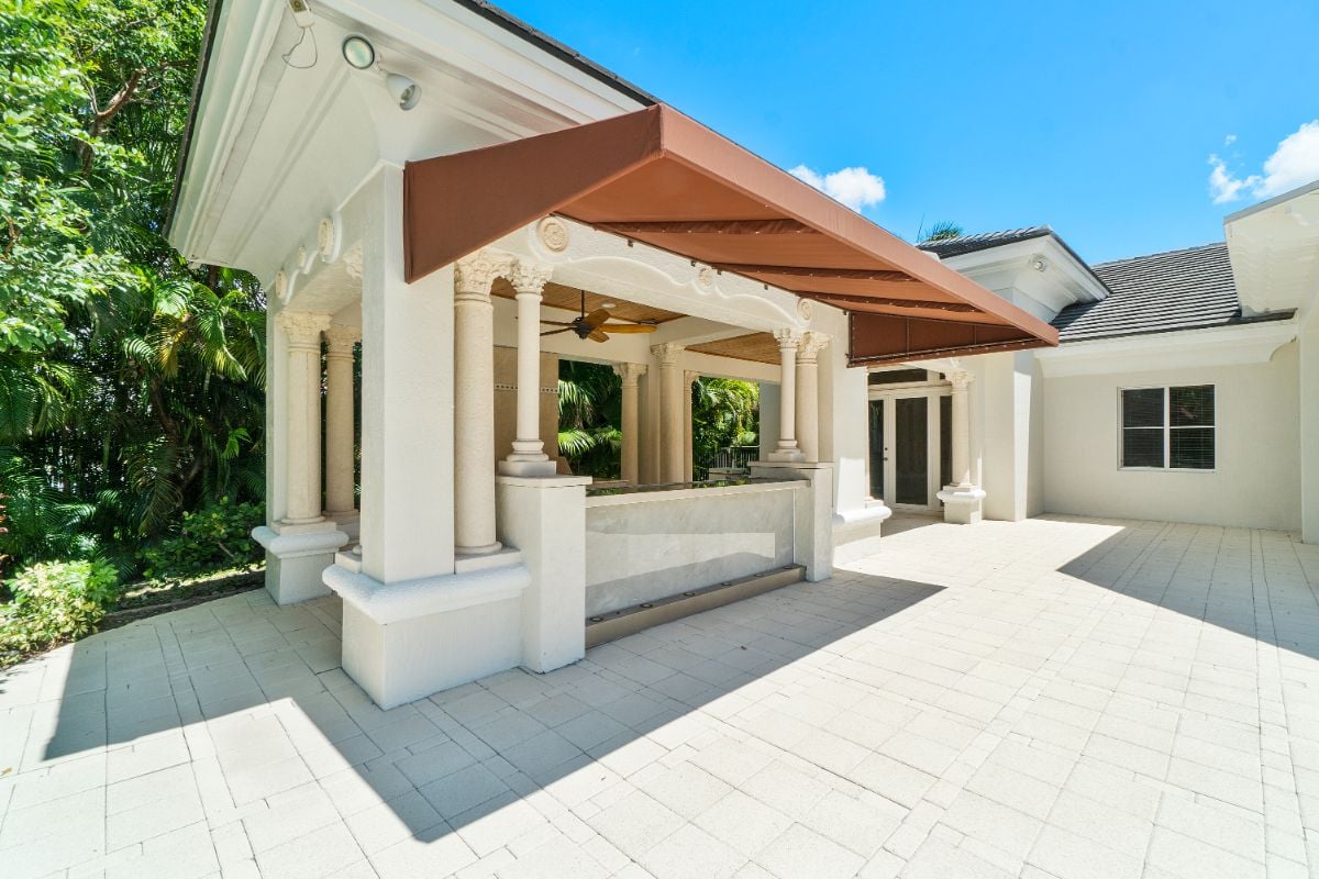 The outdoor kitchen features Corinthian columns, and a roof is installed to shade the counter.