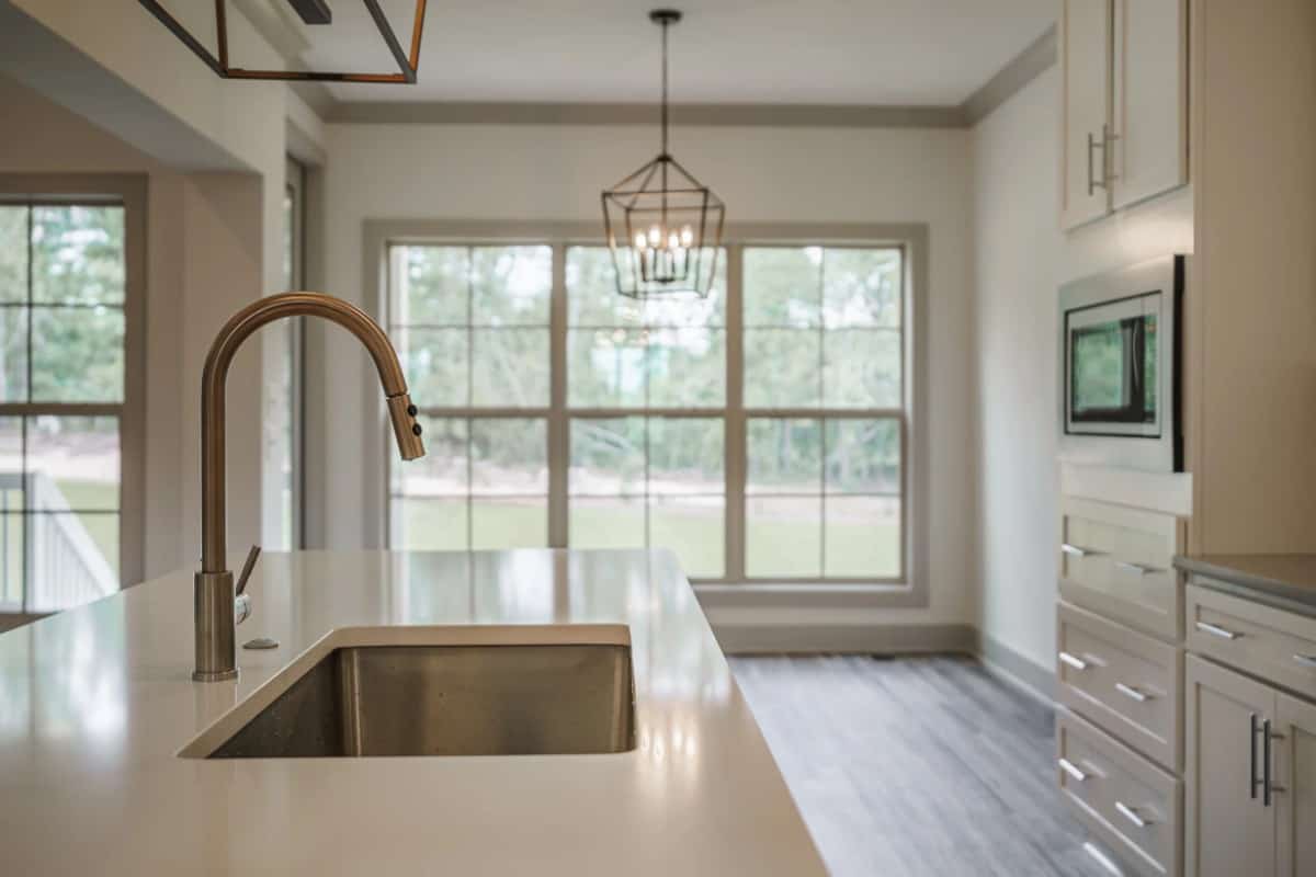 The undermount sink is paired with a gooseneck faucet in a chrome finish.