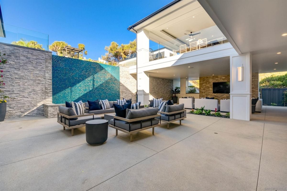 The patio located in the backyard features an outdoor fireplace and concrete flooring.