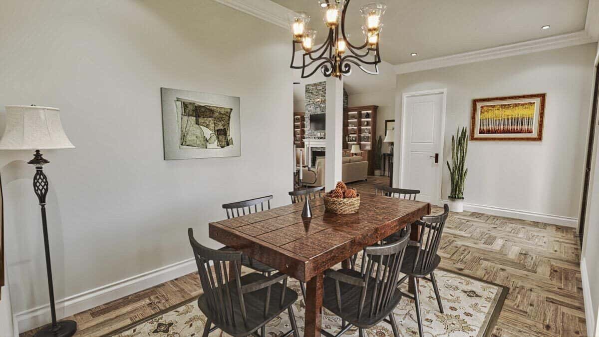 The dining room includes a wooden dining set for six sitting on a printed area rug.