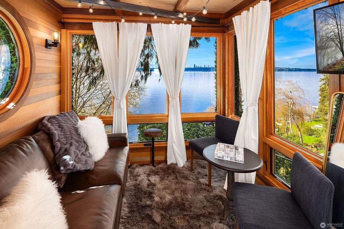 The tree house features a leather sofa, and the area rug blends well with the wooden wall giving off a rustic and cozy feel.