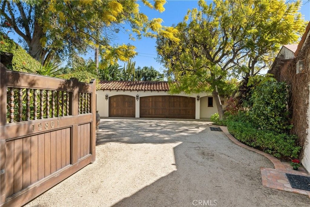 The entrance features a wooden gate with antique wall lighting, giving off a classic feel.